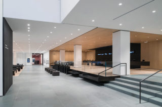 The ticketing lobby along the ground-floor West Connector, westward view, with electronic ticketing kiosks and seating. The blackened steel is inspired by the Taniguchi-designed stainless-steel portals and marks the passage between old and new galleries, such as the David Geffen Wing, part of the new western expansion passing through the 53 West 53rd Street building designed by Ateliers Jean Nouvel. Photo: Iwan Baan/Gensler.