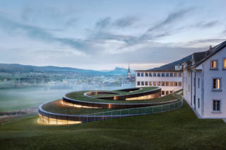 Musée Atelier Audemars Piguet, Architect: BIG – Bjarke Ingels Group. Architect of Record: CCHE. Landscape Architect: Muller Illien Landschaftsarchitekten. Location: Le Brassus, Switzerland. Photo: Iwan Baan.