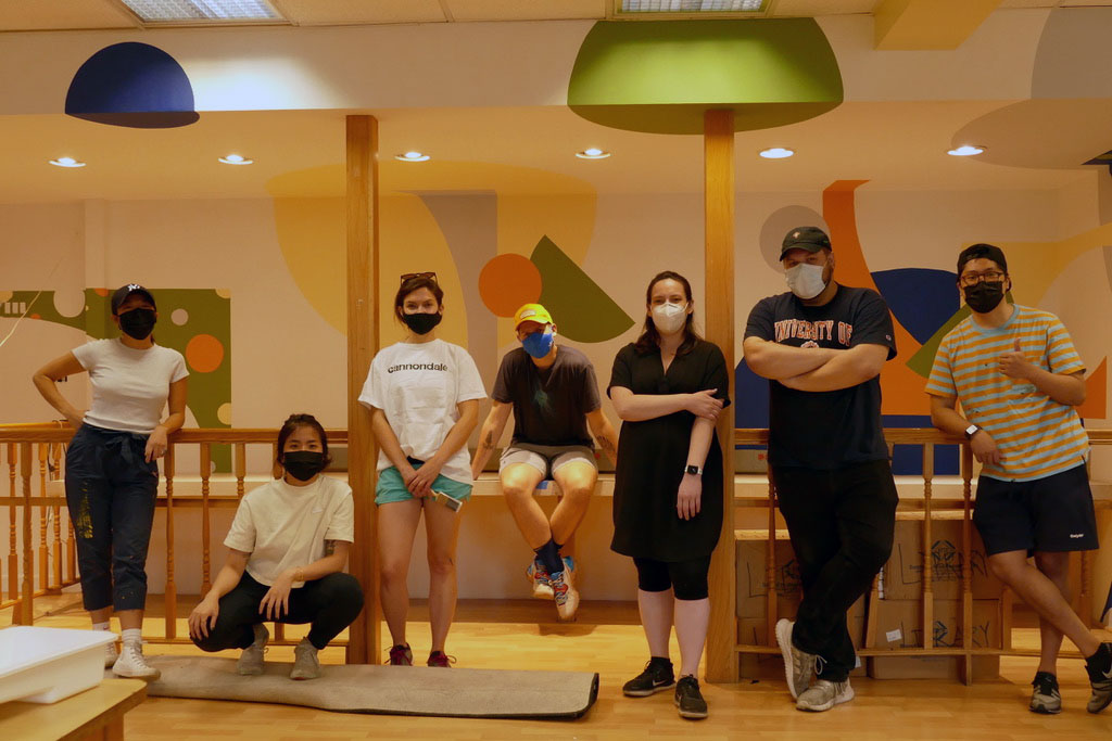 Volunteers from Ennead Architects and Richter+Ratner post with face masks inside the library they are renovating for Concrete Safaris.