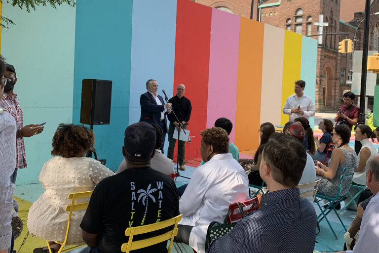 A photograph of Benjamin Prosky and Tom Eisele standing in front of a crowd at a rally in support for fossil fuel free building legislation.