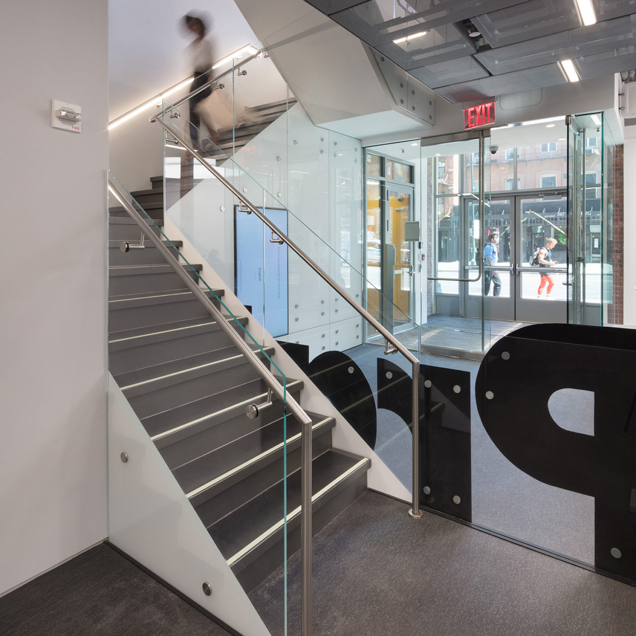 Photo of a staircase at the Hiroko Nakamoto Pratt Manhattan Lobby with a large-scale Pratt graphic.