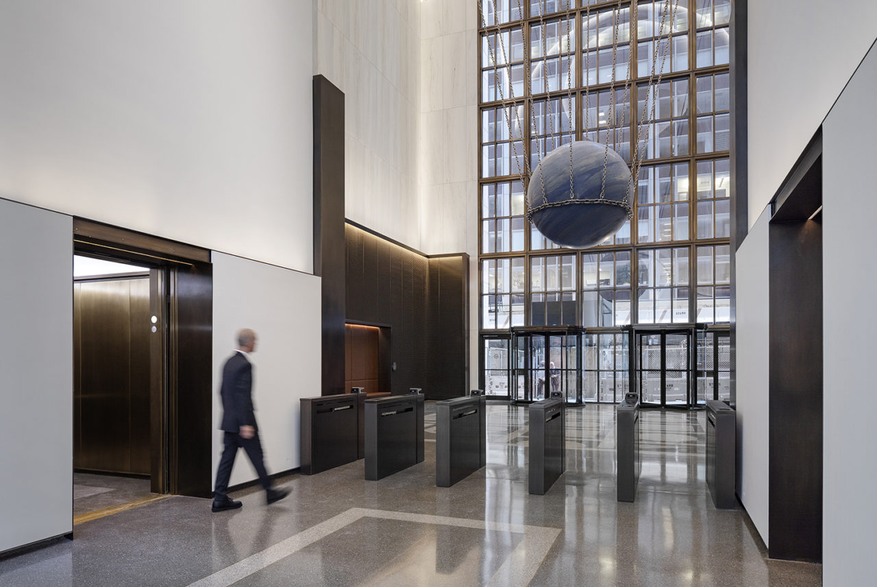 Photo of 550 Madison lobby renovation, depicting white walls and glass entrnace.