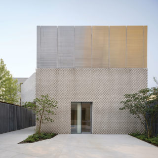 The Maujer Street gallery and Amant offices are enclosed in a single volume of white bricks set in a dog-tooth pattern. Above the masonry section, a band of aluminum louvers diffuses daylight into a 22-foot-tall gallery space.