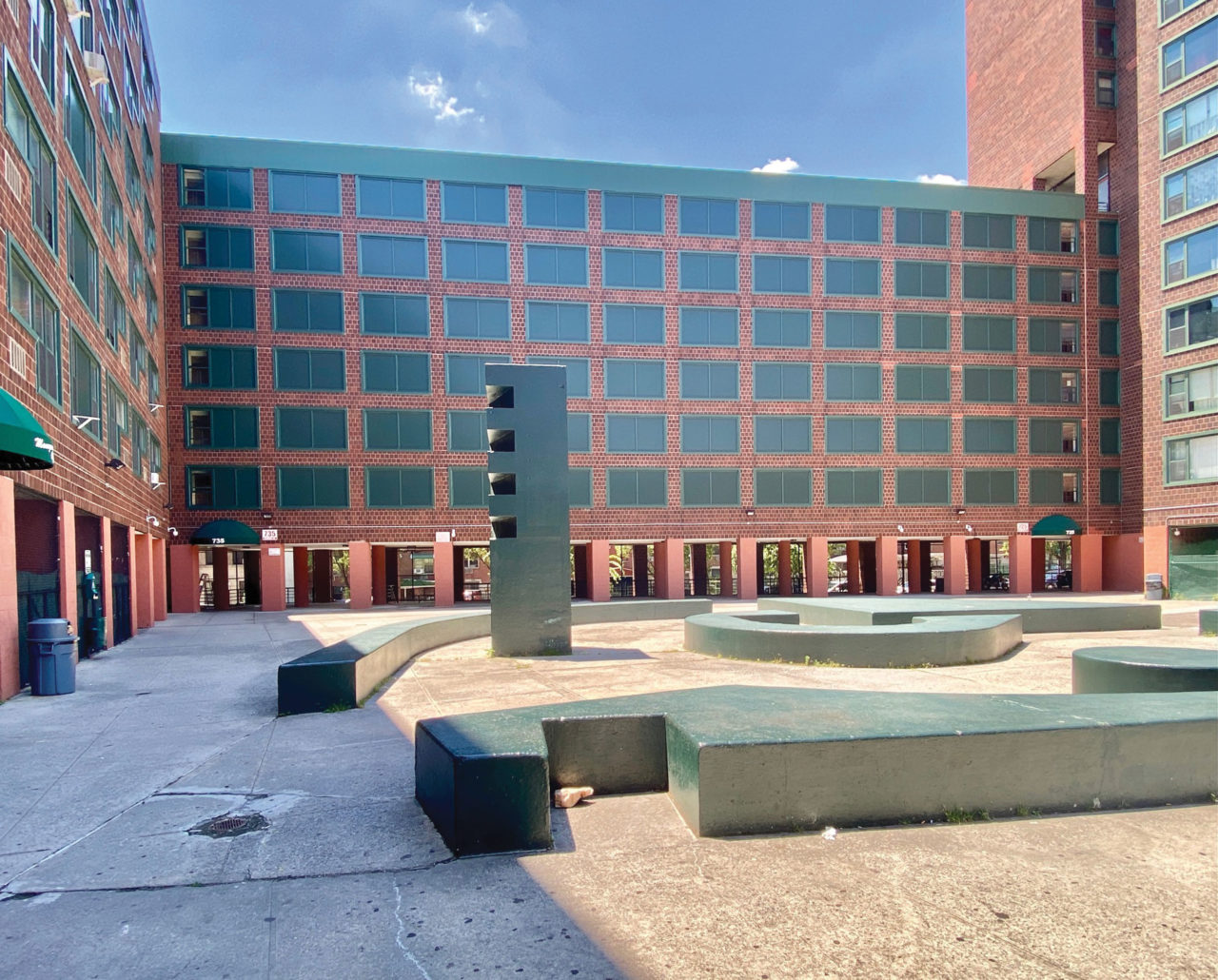 A present-day photograph of Twin Parks affordable housing in the Bronx, which has suffered from maintenance and security issues. Windows have been covered with green shutters to avoid more extensive repairs.
