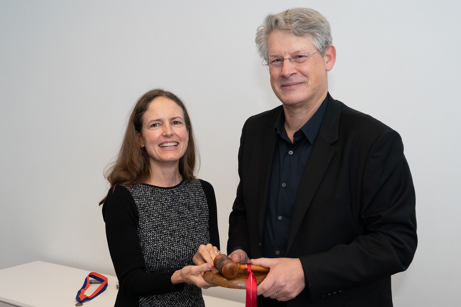Photo of Ken Lewis passing a wooden gavel to Andrea Lamberti.