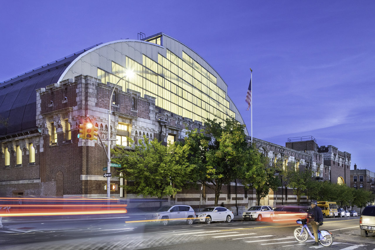 Photo of the exterior of the Photo of the interior athletic spaces at the Major R. Owens Health & Wellness Center at the Bedford Union Armory.