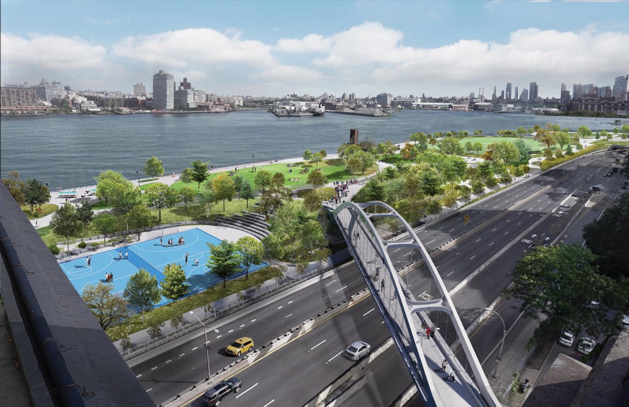An elevated pedestrian crossing leading to a riverside park