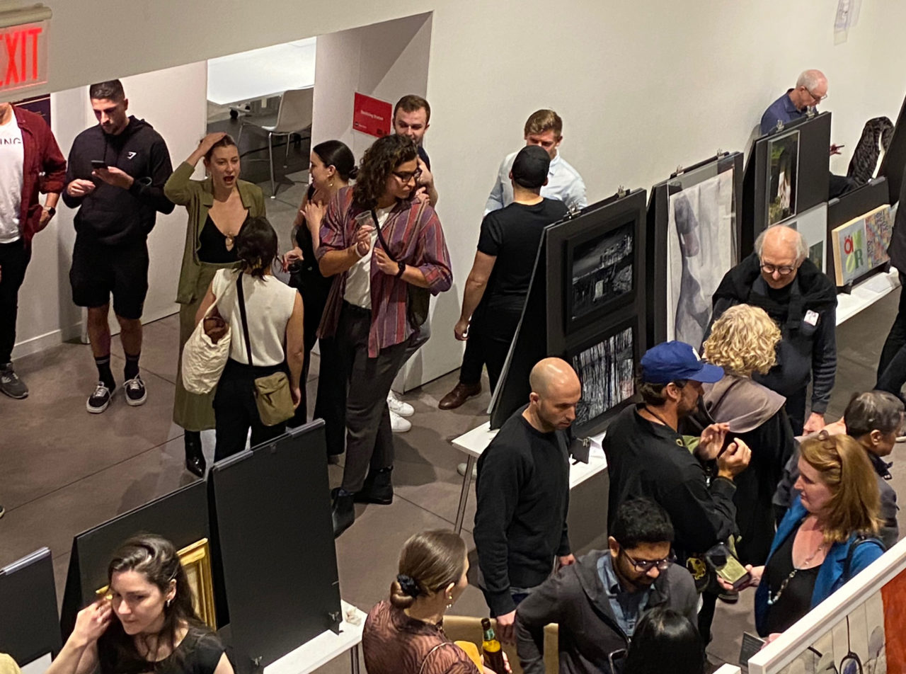 Large crowd at an exhibition opening.