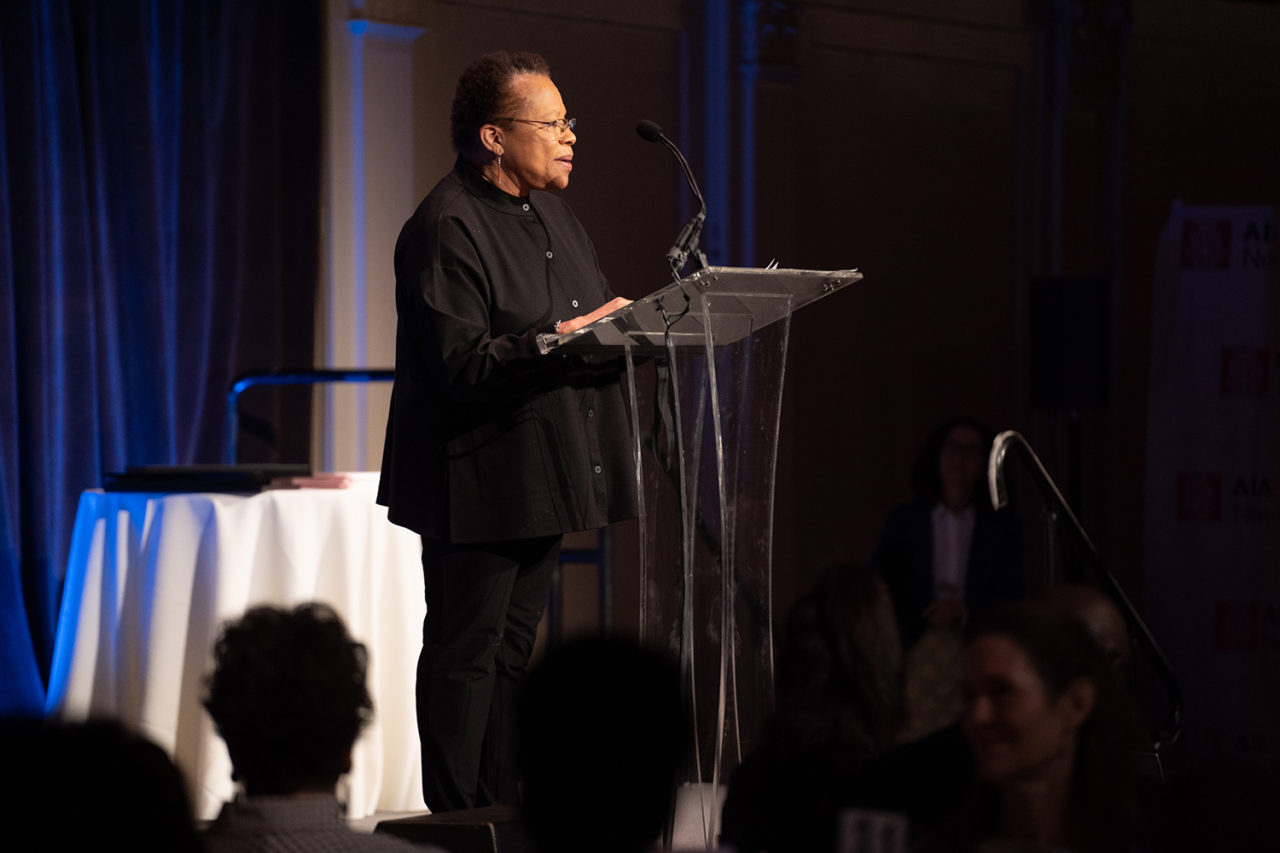 A woman stands at a podium.
