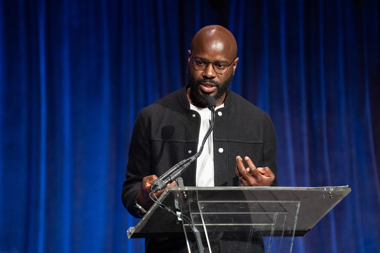 A man stands over a podium