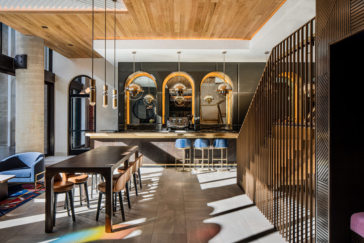 Lounge furniture at the forefront leads to a bar with gold accents