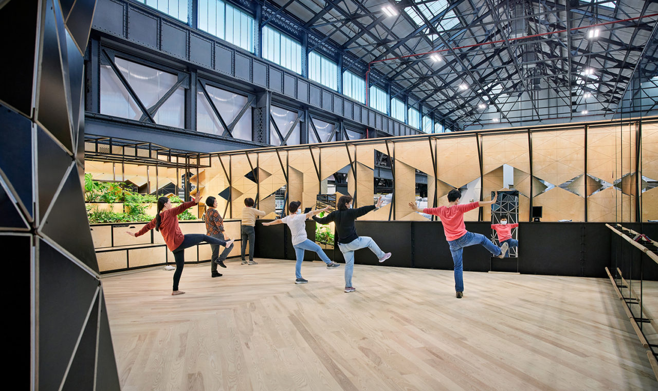 Six people do exercise inside a open-ceiling space