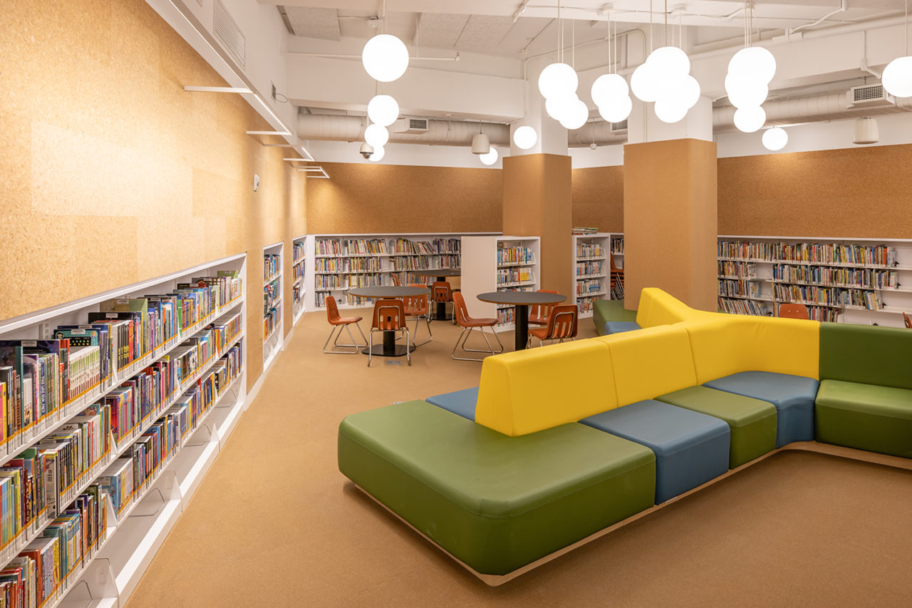 Interior of a library space featuring bookshelves and large, colorful seating