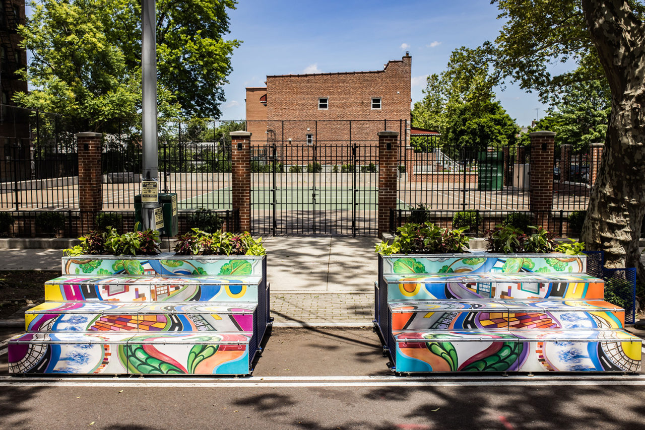 Two colorful, stepped structures in front of the entrance to a building.