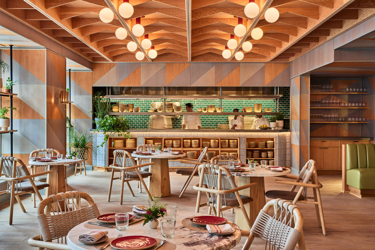 A restaurant interior featuring natural wood and plants.