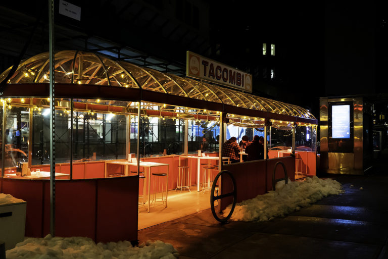 Outdoor dining structure with lights at nighttime