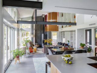 A kitchen counter in the foreground with an airy living area in the background