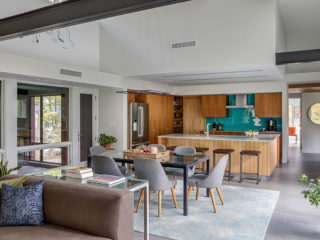 A modern interior with a dining table and a kitchen in the background