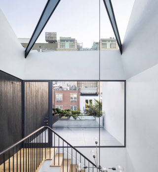 A stairwell with a skylight and a door connecting to an outdoor area