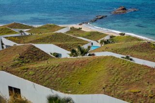 The green rooftops of the Marea housing development in Lebanon as seen from the top, with a part of the ocean in the background