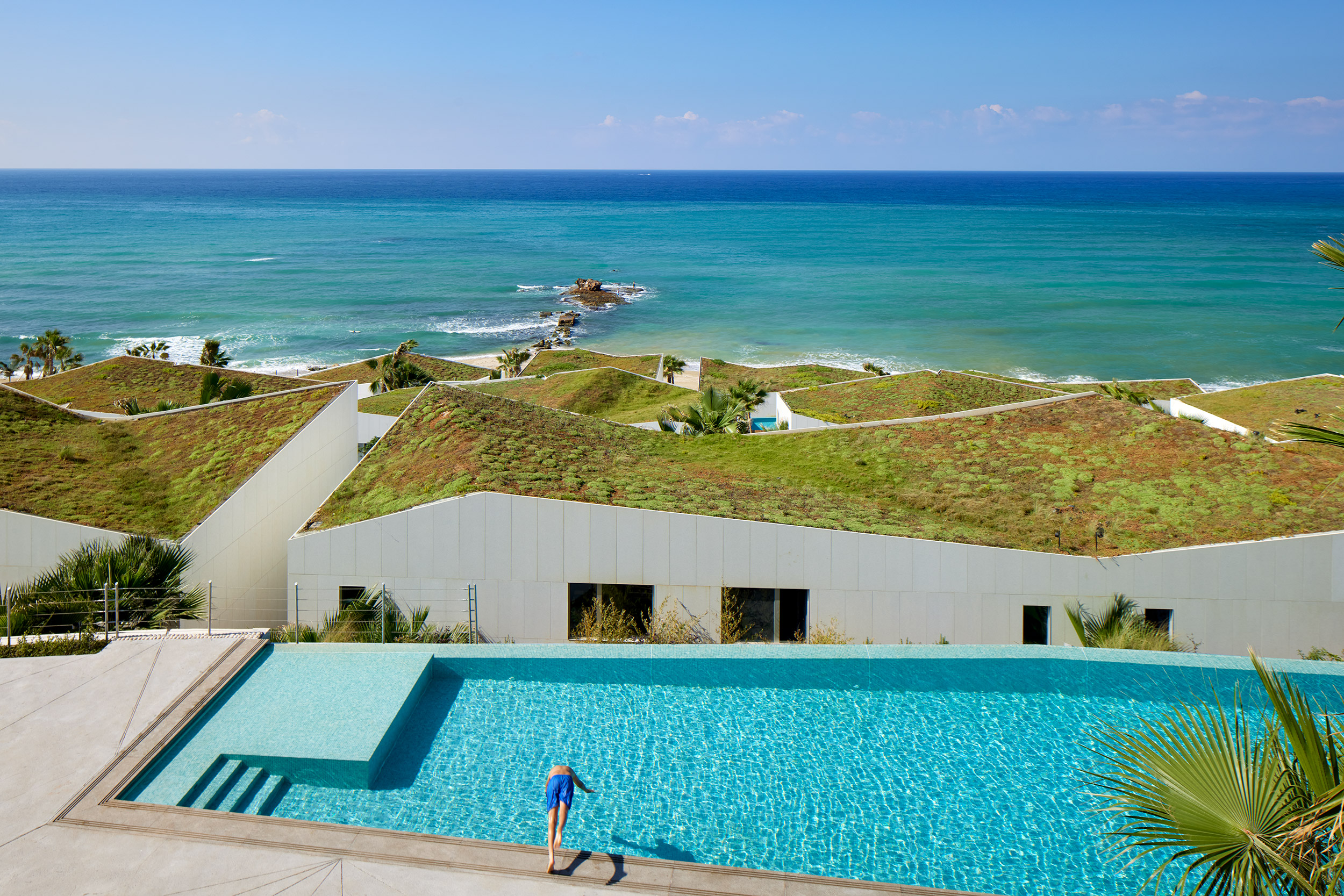 The exterior of the Marea housing development in Lebanon with a swimming pool in the foreground and the ocean in the background