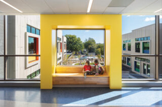 Interior of John Lewis Elementary School with two children sitting in a sunny window seat