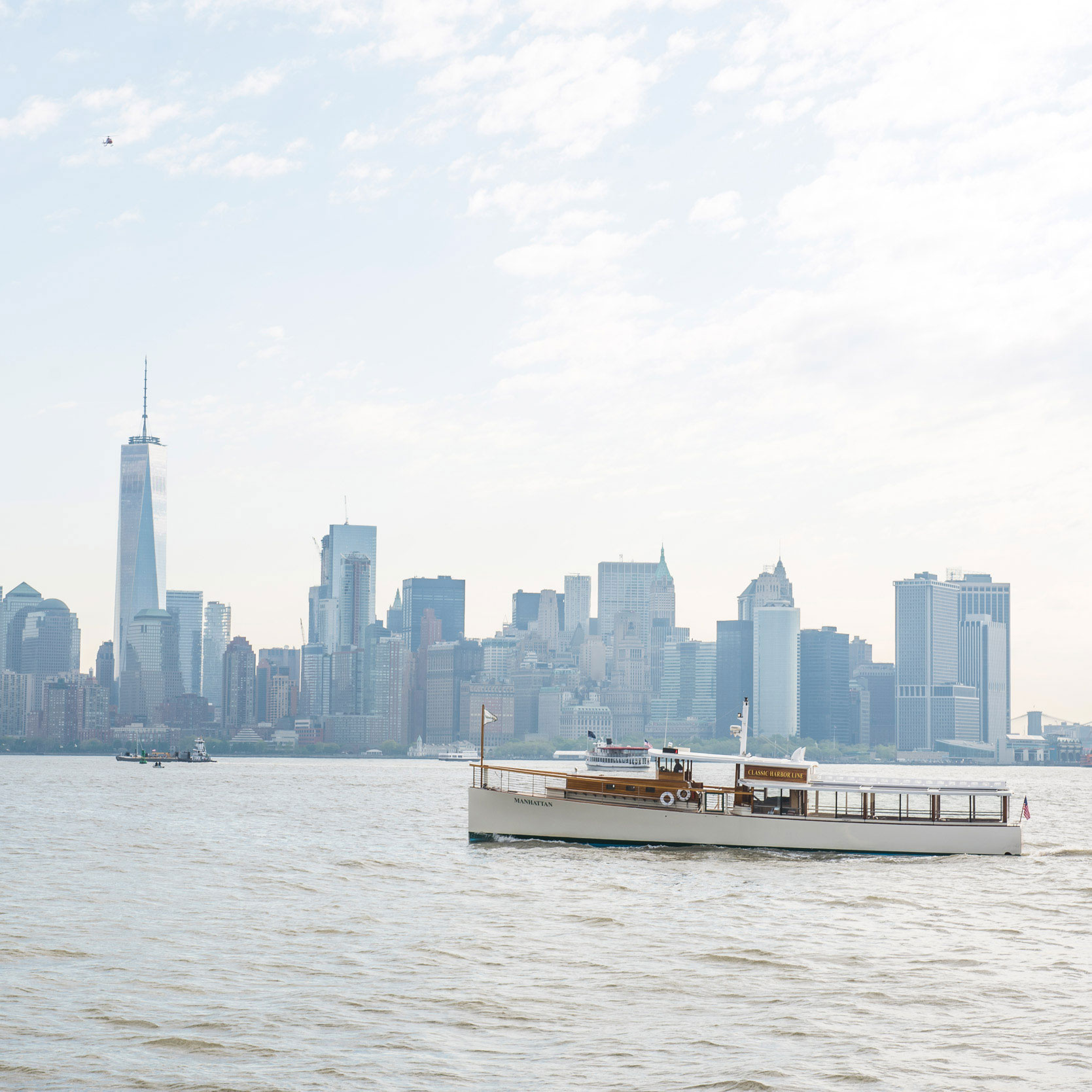 A Classic Harbor Line yacht on the water with the NYC skyline in the background