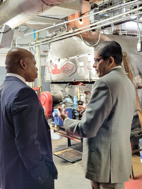School Construction Authority Managing Engineer Deoraj Persaud looks at an antiquated boiler at PS 5 in Manhattan with NYC Mayor Eric Adams