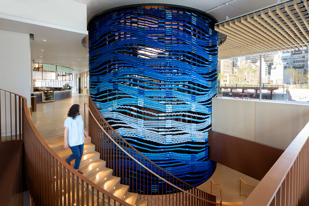 A swirling staircase around a centerpiece blue wall fixture.