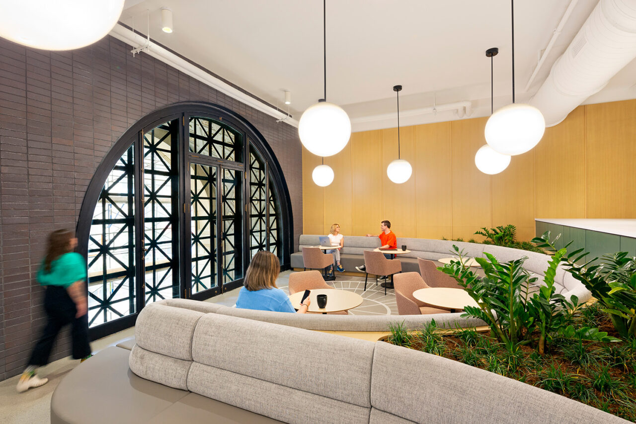 A bright office space with a black metallic archway.