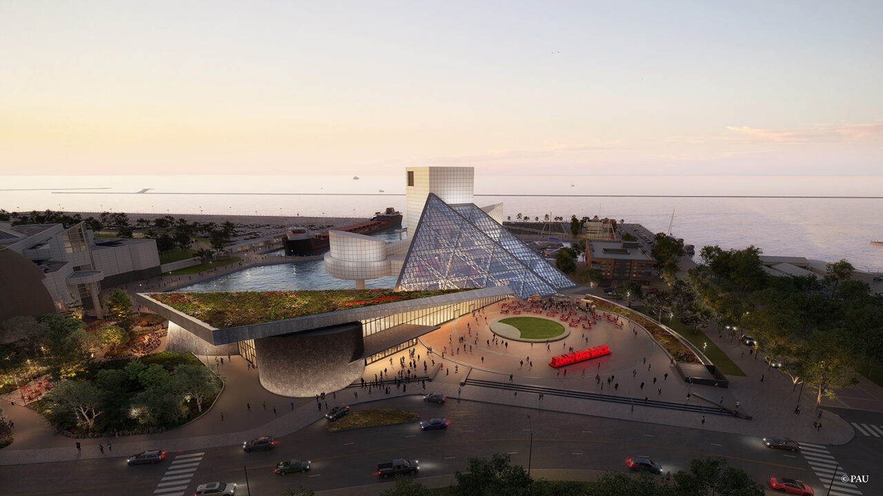 A further zoomed out perspective of the Rock & Roll Hall of Fame in Cleveland, OH, built against the urban lakefront.
