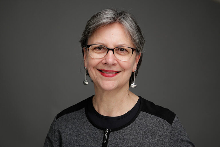 Barbara Weinreich headshot (white woman, short gray hair, dangly silver earrings, gray top)