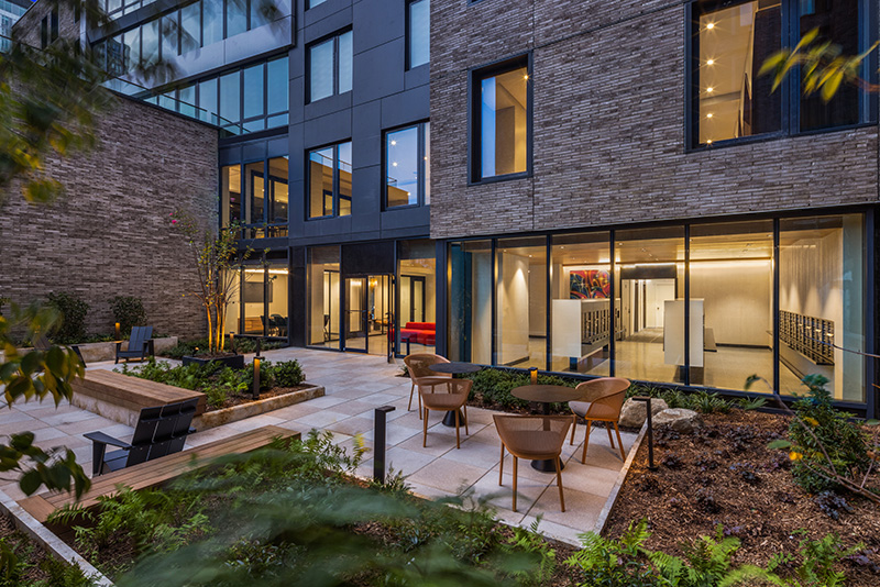 The courtyard of 2413 Third Avenue with benches, seats, and tables.