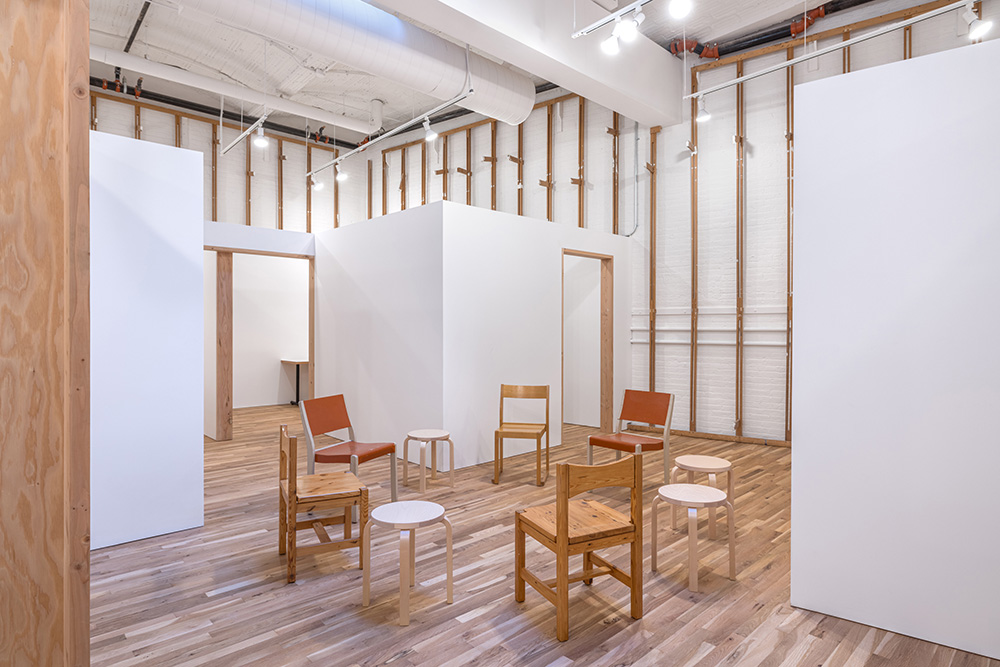 White room with light wood floors and chairs. Inside the ISP studio.