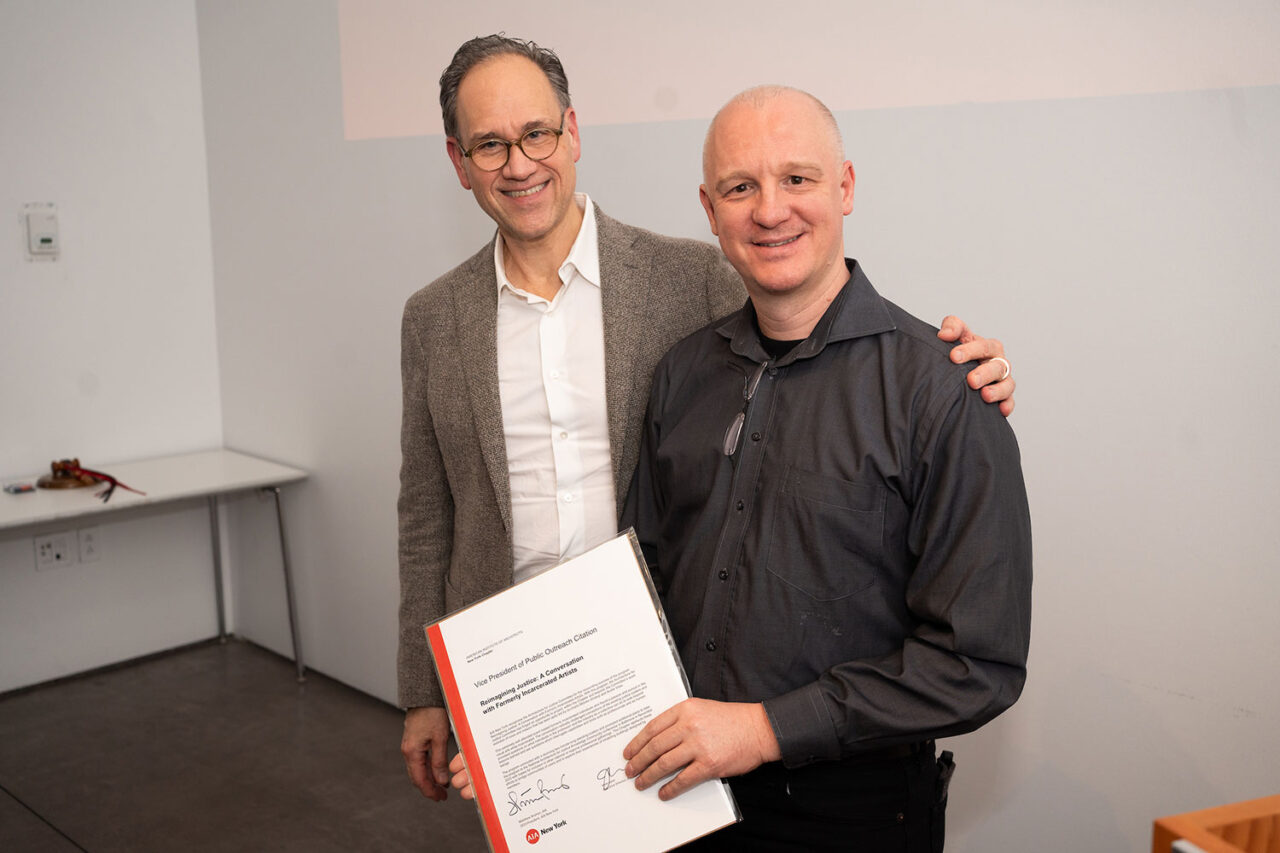 Rocco Giannetti passes the AIANY Citation for Public Outreach award certificate to Andre Voss