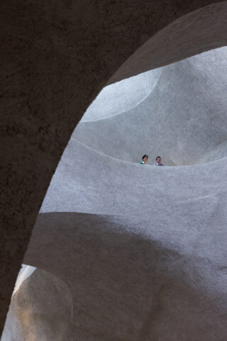 Two faces poke out from the curvature of the interior of the Richard Gilder Center.