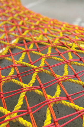 Soft Fits, a site-specific installation by Brooklyn's WIP Collaborative, creates a playful lounge-scape for people of all ages to hang out, explore, and connect in the heart of downtown Toronto. A red and yellow knit structure.