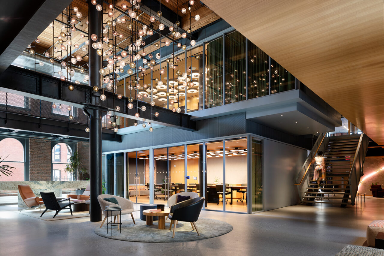 Interior of an office building with hanging lights above a central gathering area.