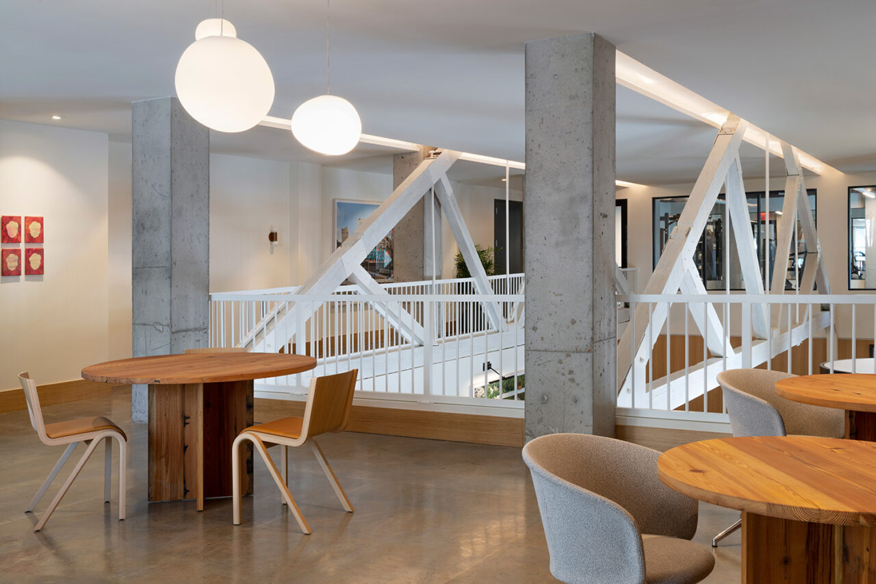 The second story of an interior building. Tables and chairs in the foreground.