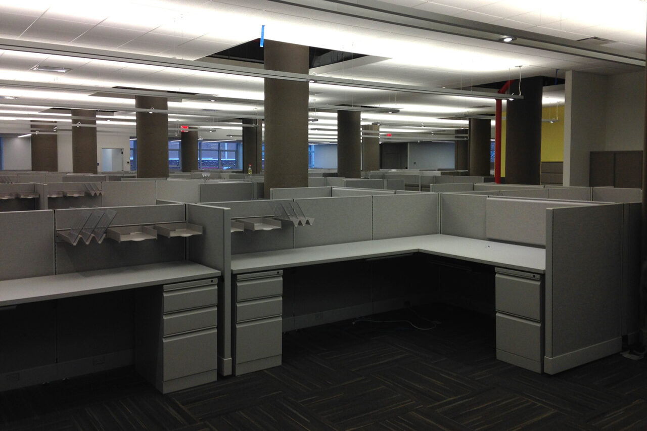 Interior of office space, focusing on a cubicle/area with a desk, and drawers.