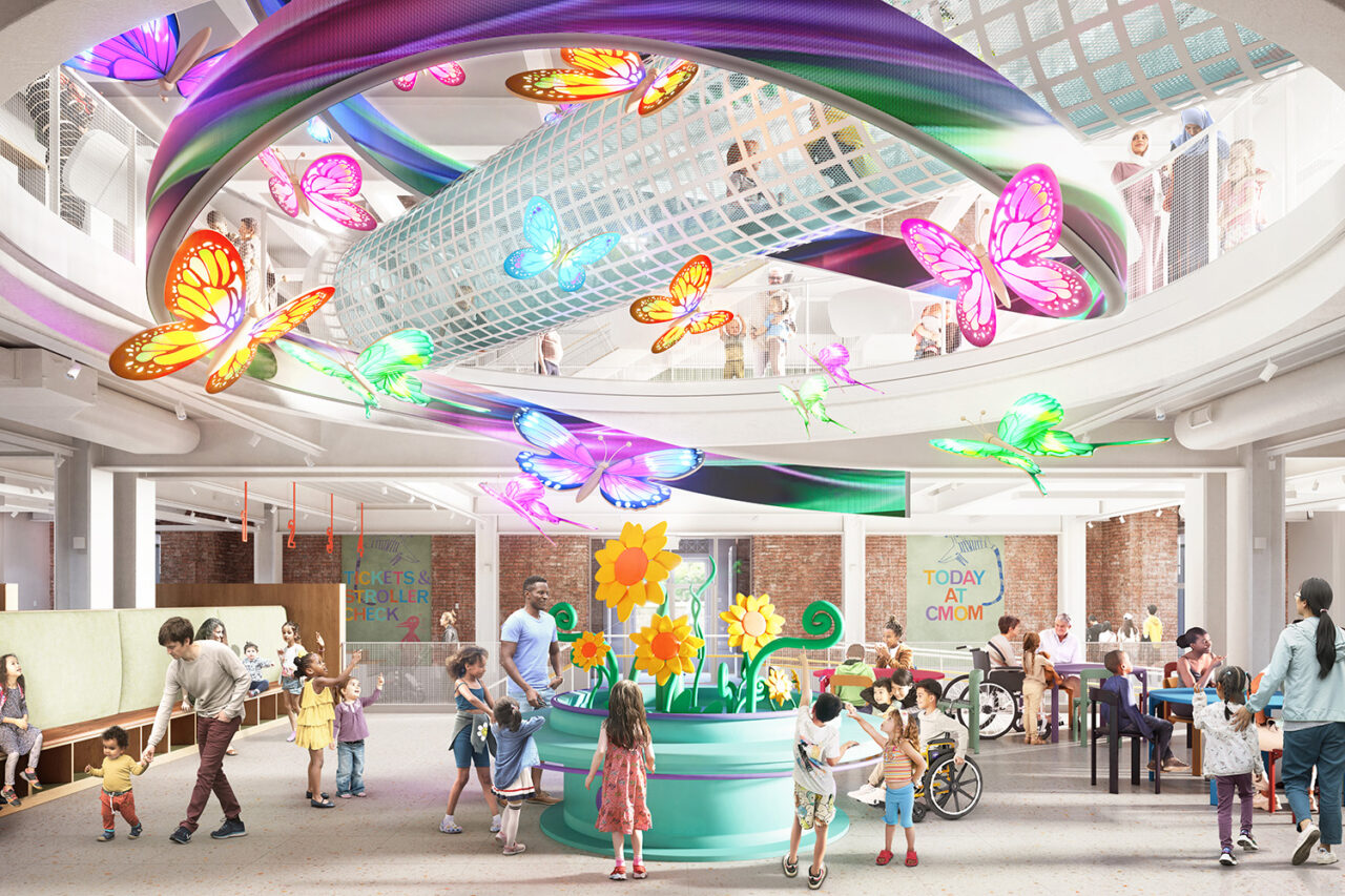 A rendering of the lobby, with colorful butterfly structures hung above, and children and families roaming the ground floor.