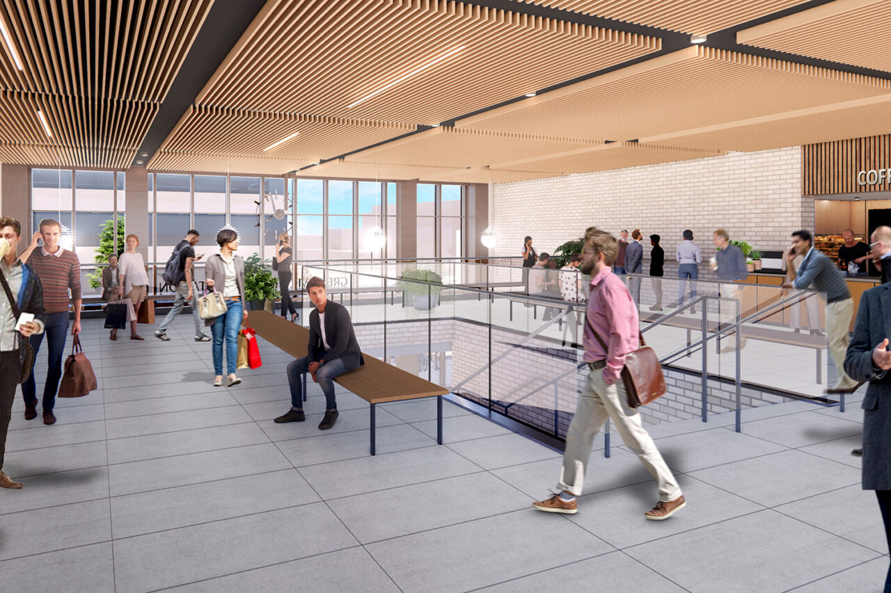 Rendering of interior train hub, with a coffee shop in view and people bustling about.