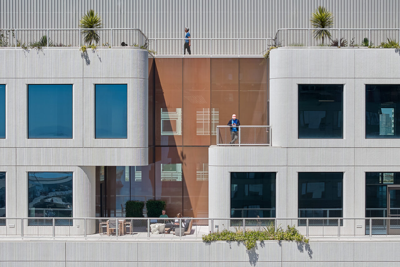 An exterior view of various people standing on different levels of the building.