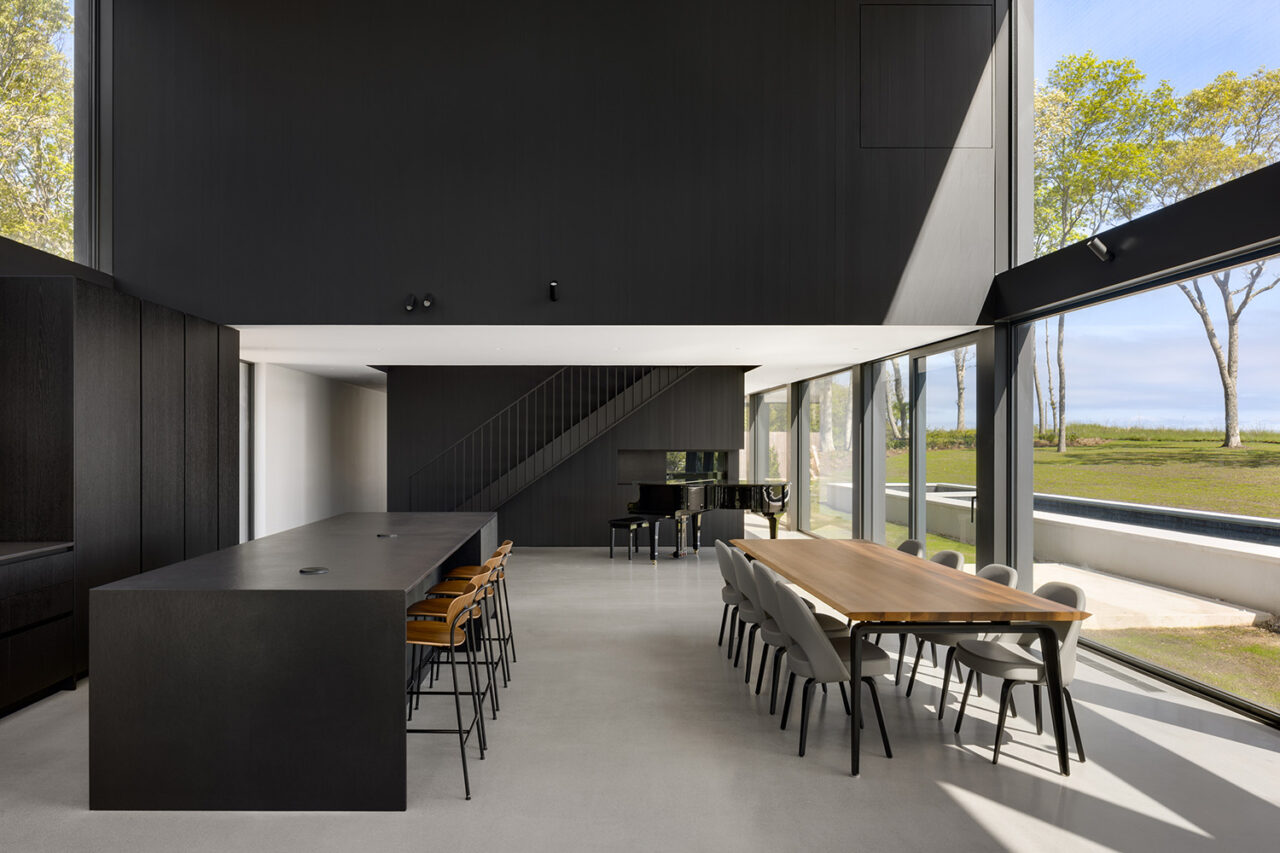 Frame House interior, well-lit, black kitchen island in view.