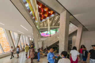 Interior shot with people sitting around in the central area of Far Rockaway Library.
