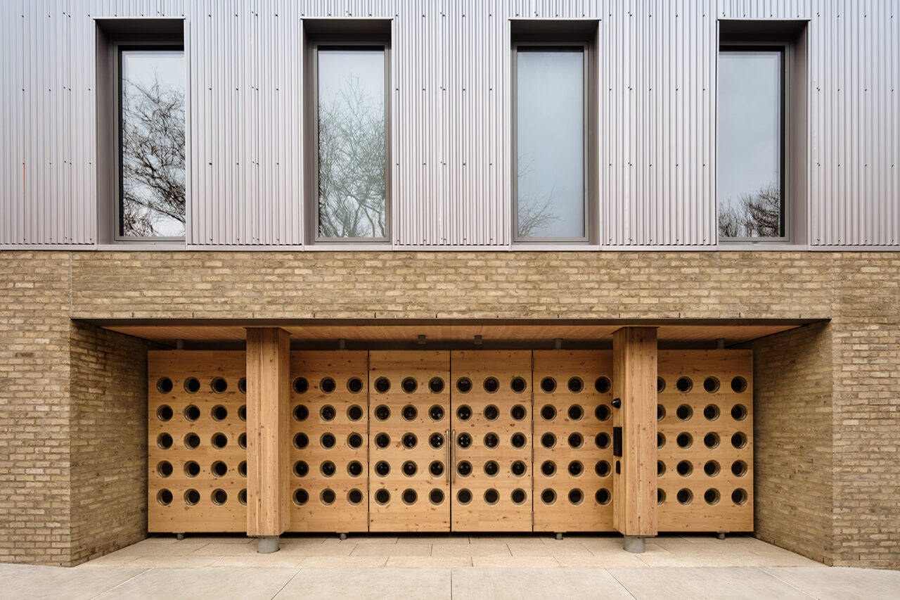 Exterior of apartment with wooden doors that have punctured holes as decoration.