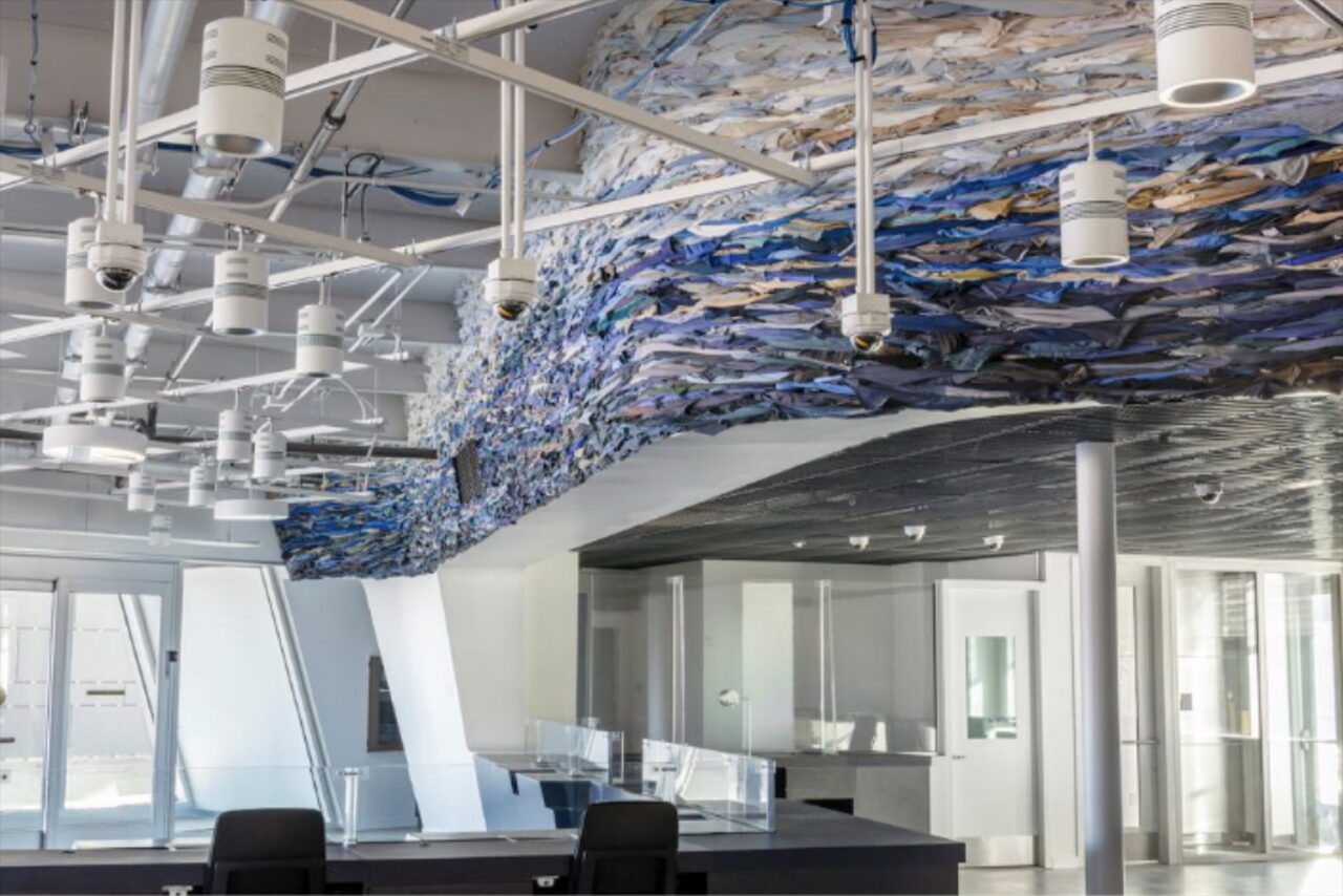 Public artwork cascades across the ceiling in an office space.