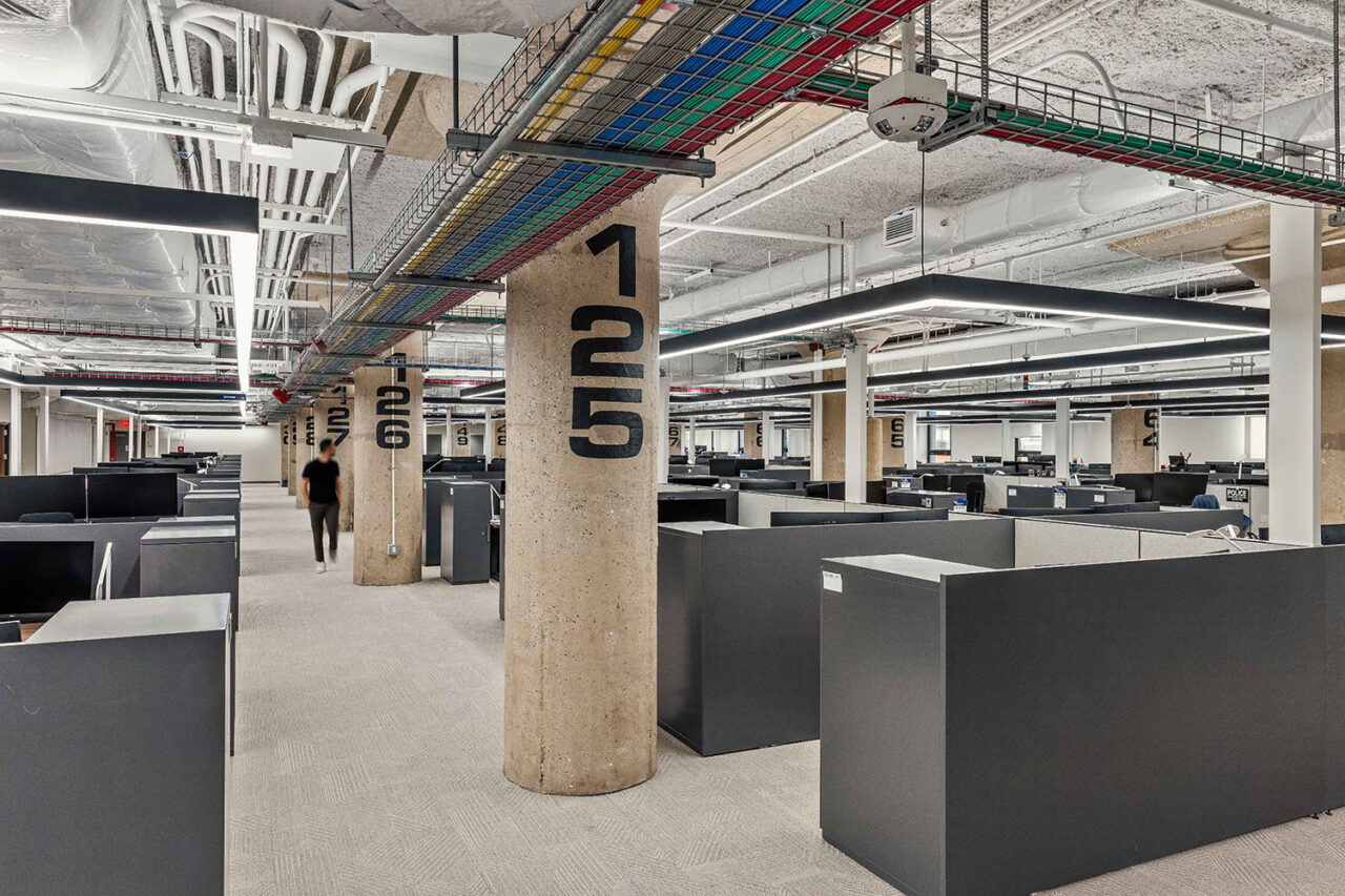 Inside of Manhattan Field Office with many black cubicles shown.
