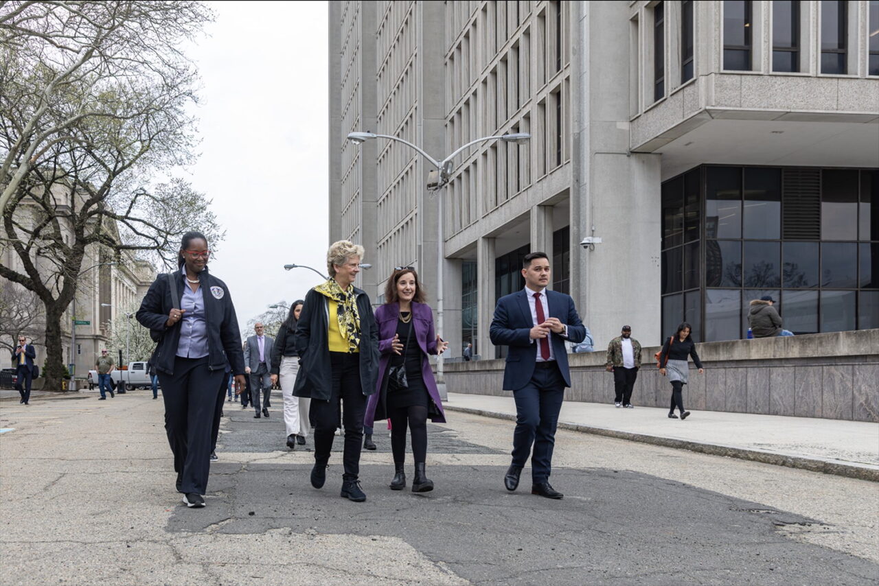 Four people walk along the street in Newark, NJ..