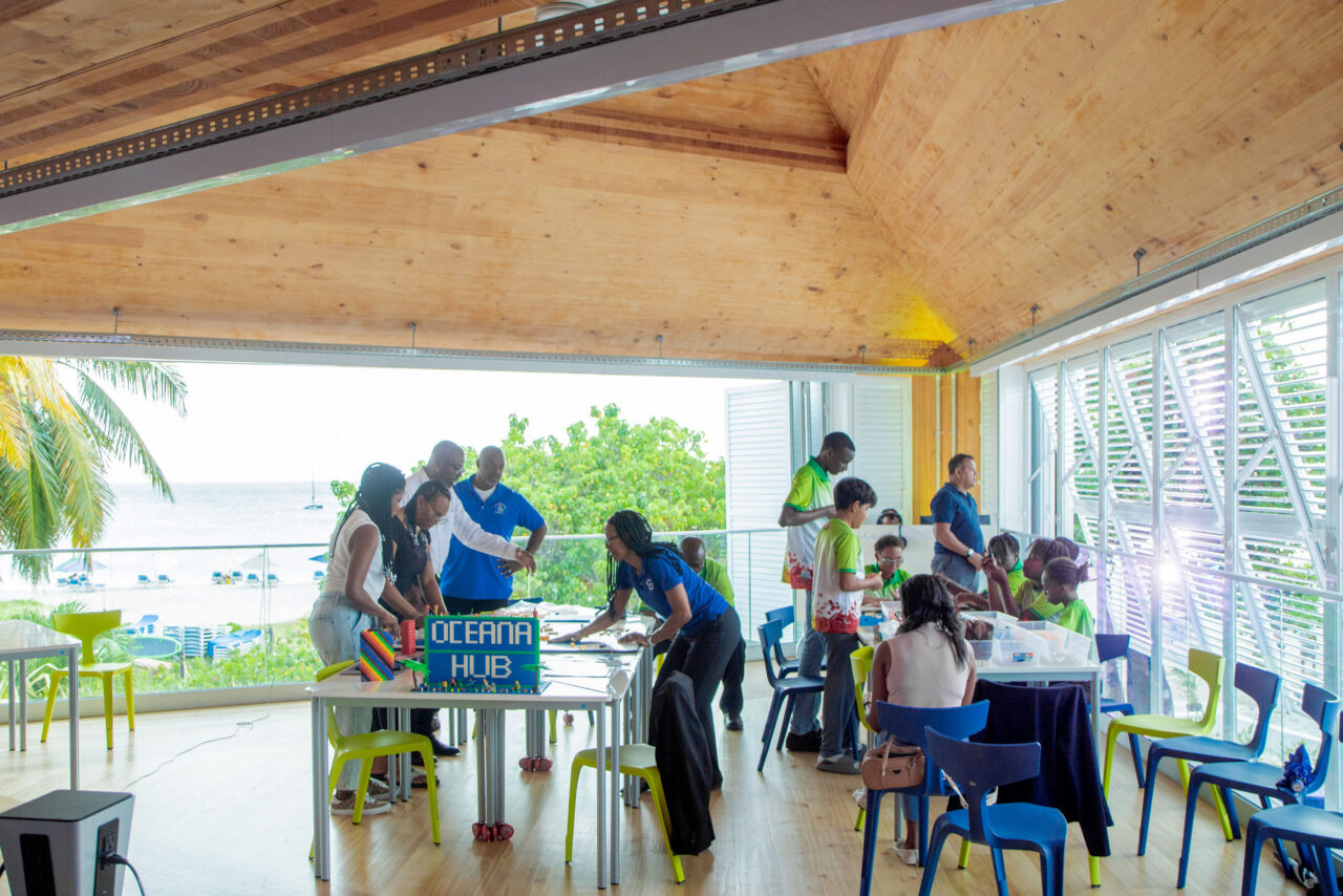 AMMA’s design of the Oceana Innovation Hub in Barbados borrows from the Barbadian chattel house, using passive ventilation, steep roofs, prefabrication, and natural materials to connect students to climate and place while minimizing energy use and embodied carbon.